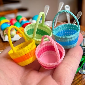 May include: Four small, colorful, woven baskets with handles. The baskets are striped in green, blue, yellow, and pink.