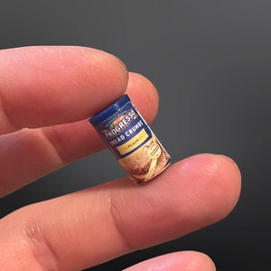 May include: A blue and yellow can of Progresso Bread Crumbs, labeled "Plain".
