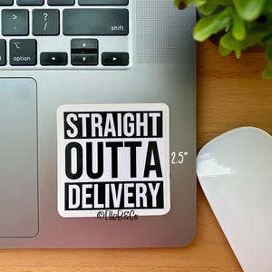 May include: A white sticker with black text that reads "STRAIGHT OUTTA DELIVERY" with the text "2.5" in the top right corner and "@ElleB&Co" at the bottom. The sticker is on a silver laptop.