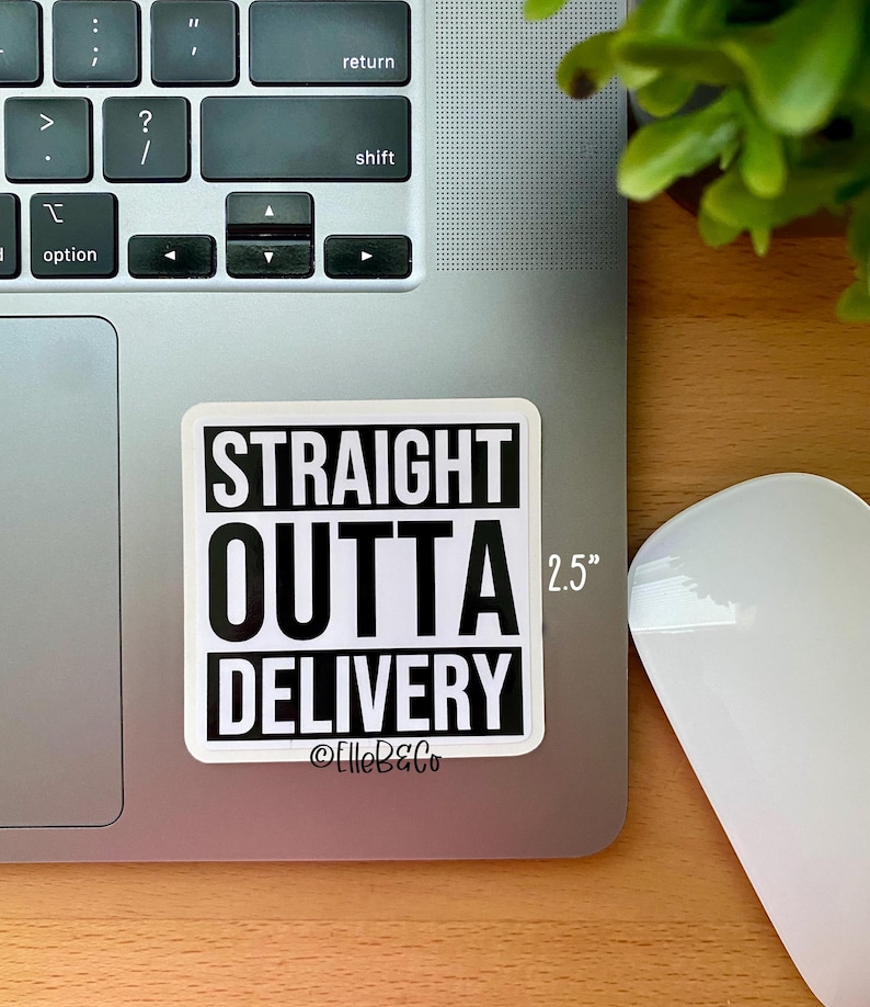 May include: A white sticker with black text that reads "STRAIGHT OUTTA DELIVERY" with the text "2.5" in the top right corner and "@ElleB&Co" at the bottom. The sticker is on a silver laptop.