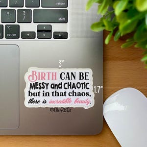 May include: A white sticker with black text that reads "BIRTH CAN BE MESSY and CHAOTIC but in that chaos, there is incredible beauty." The sticker is 3 inches wide and 1.7 inches tall. The text is in a pink font. The sticker is on a silver laptop.