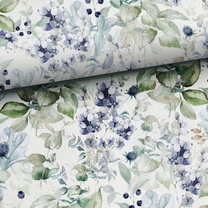 Könnte beinhalten: Ein Stoff mit einem Aquarell-Blumenmuster. Das Design zeigt blaue Beeren, grüne Blätter und zarte blaue Blüten auf weißem Hintergrund. Der Stoff ist gefaltet und zeigt die Wiederholung des Musters.