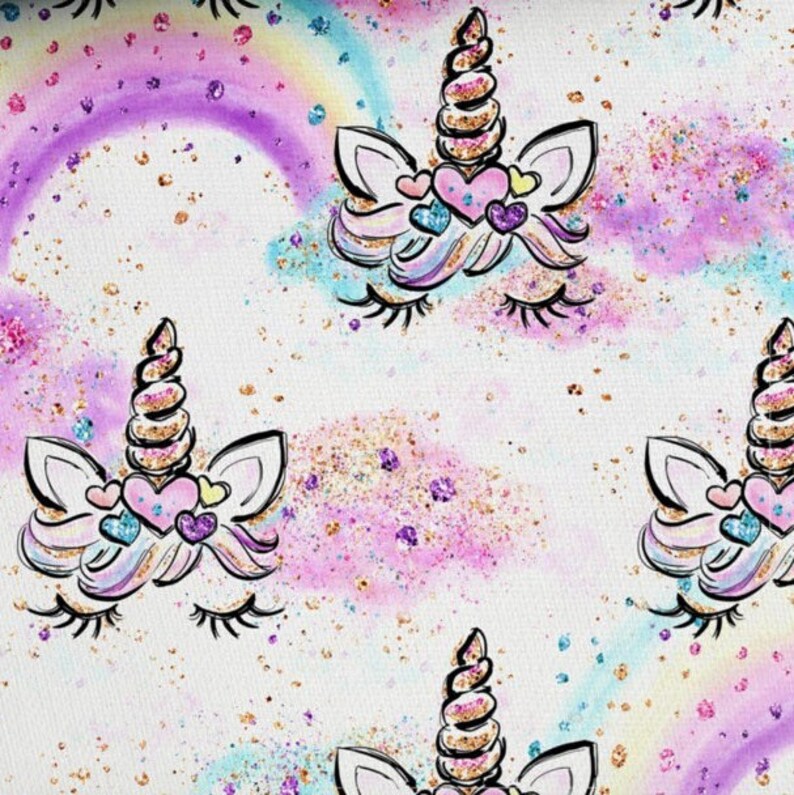 May include: A white background with a repeating pattern of unicorn faces. The unicorns have gold glitter horns, pink and purple glitter manes, and closed eyes. The background is covered in gold, pink, and purple glitter.