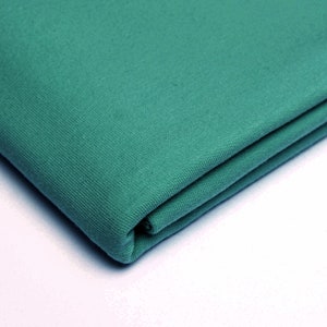 Peut inclure: Un morceau de tissu turquoise plié avec une surface douce et texturée.