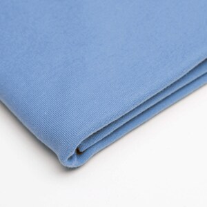 May include: A folded piece of light blue fabric. The fabric has a soft, textured surface.