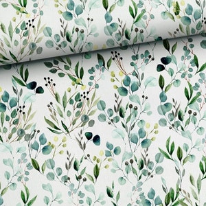 Peut inclure: Tissu blanc avec un motif aquarelle de feuilles d'eucalyptus vertes et de petites baies noires. Les feuilles varient en nuances de vert et de vert-bleu, créant un design botanique naturel. Le tissu est plié, montrant la répétition du motif.