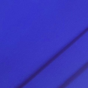 May include: A close-up of a vibrant blue fabric with subtle diagonal lines, creating a textured appearance. The fabric is a solid color, with a slight sheen, and appears to be a smooth, woven material.