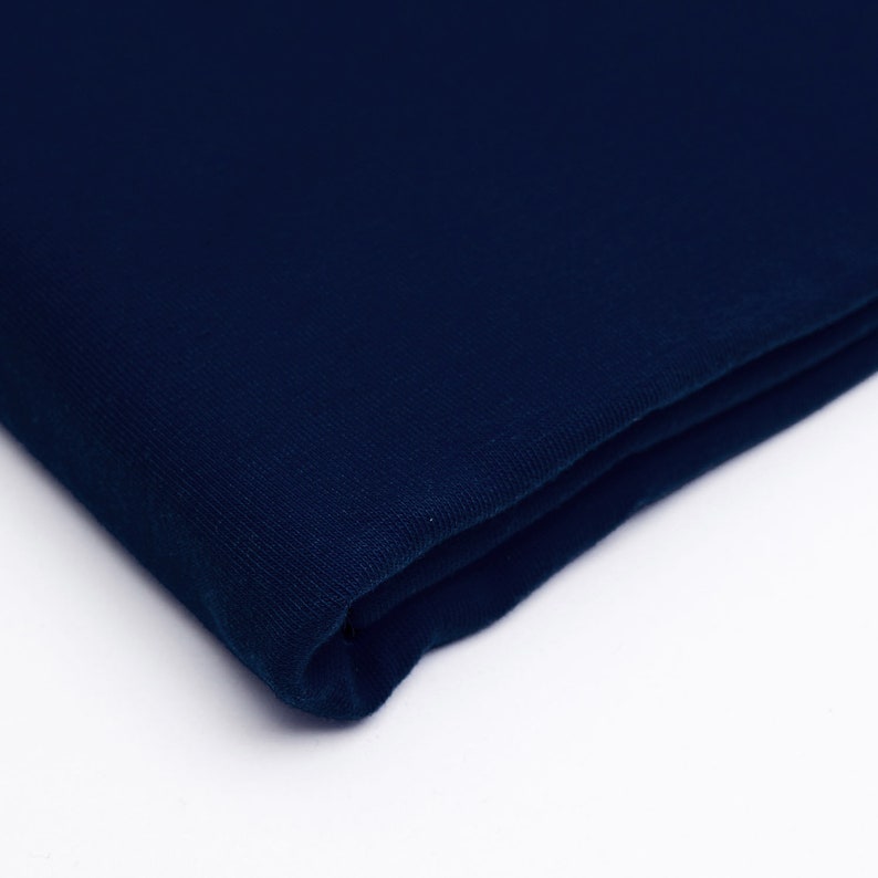 May include: A folded piece of dark blue fabric. The fabric has a soft, textured surface.