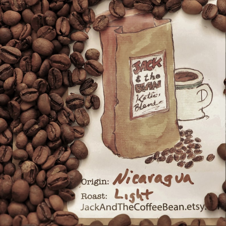 May include: A watercolor illustration of a coffee bag with the text "Jack & the Bean Katia's Blend" and the words "Origin: Nicaragua Roast: Light" below. The bag is surrounded by coffee beans.