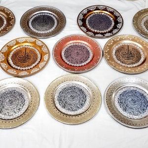 May include: A collection of 15 decorative plates with intricate designs and Arabic calligraphy. The plates are in various colors, including gold, silver, copper, and blue. They are perfect for adding a touch of elegance to any home decor.