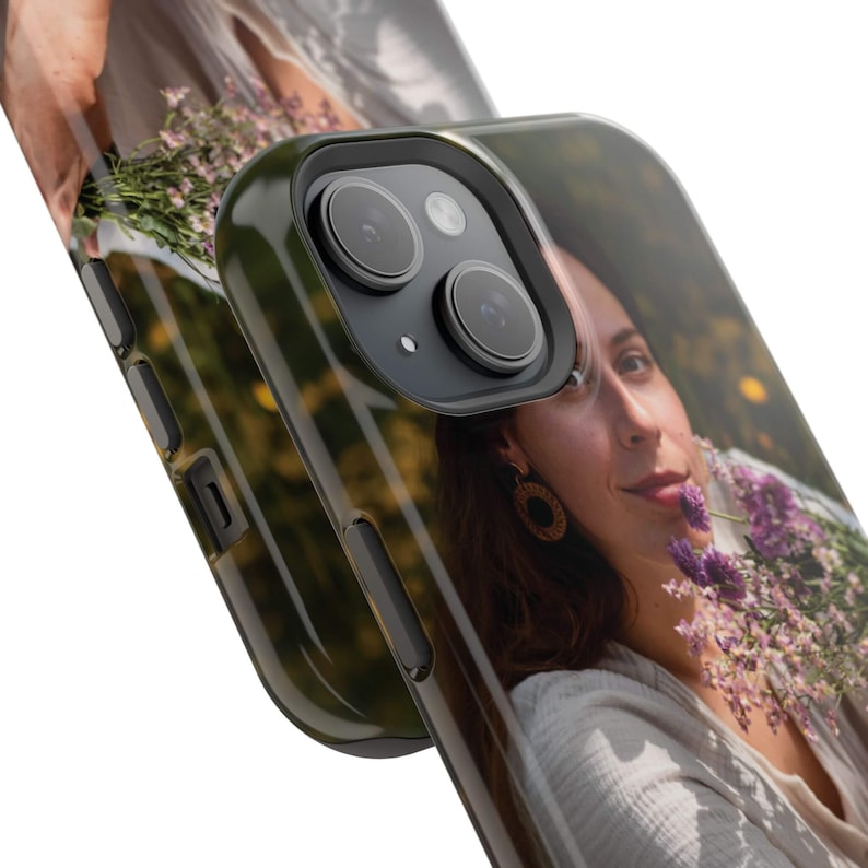 May include: A clear phone case with a photo printed on the back. The photo shows a person holding a bouquet of purple flowers. The case has a black border and a camera lens cutout.