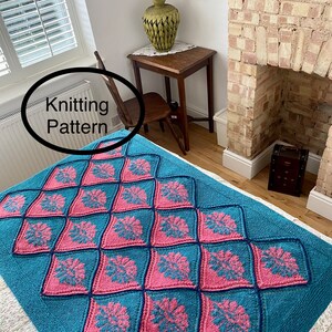 May include: A teal blue knitted throw blanket with a pink and blue diamond pattern. The blanket is on a white bedspread and has the words "Knitting Pattern" written on it.