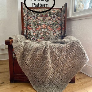 May include: A gray knitted blanket with a diamond pattern is draped over a wooden chair with a floral patterned back. The text "Knitting Pattern" is in a white oval above the chair.