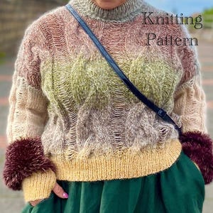 May include: A multi-colored knitted sweater with a cable knit pattern. The sweater has a high neck and long sleeves. The sleeves have a fluffy trim. The sweater is a mix of pink, green, and beige colors. The text "Knitting Pattern" is visible in the image.
