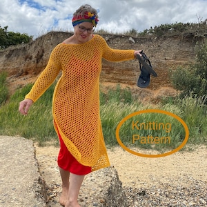 Puede incluir: Una mujer lleva un vestido de crochet amarillo con una falda roja debajo y una diadema arcoíris. Está de pie en una cornisa de hormigón con una playa rocosa detrás. El texto "Knitting Pattern" está escrito en un círculo en la imagen.