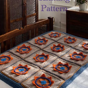 May include: Knitting pattern for a blanket with a geometric design featuring orange and blue flowers on a beige background. The blanket has a blue border.