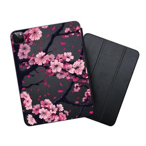 May include: A black iPad case with a floral design featuring pink cherry blossoms on a dark gray background. The case has a matching black folio cover.