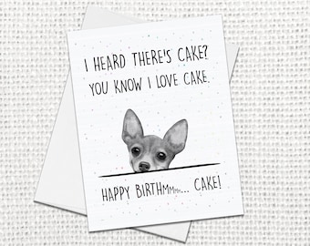 May include: A white greeting card featuring a watercolor illustration of a small dog peeking over a black horizontal line. The text reads: I HEARD THERE'S CAKE? YOU KNOW I LOVE CAKE. HAPPY BIRTHMMM... CAKE! The card has small colorful confetti dots.