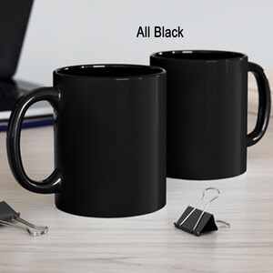 a couple of black coffee mugs sitting on top of a table