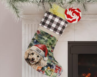 Könnte beinhalten: Ein Weihnachtsstrumpf mit schwarz-weißem Karomuster am Umschlag und einem Aufdruck eines lockigen Hundes mit roter Weihnachtsmütze, auf deren Rand der Name CHLOE steht, vor dem Hintergrund eines geschmückten Weihnachtsbaums.