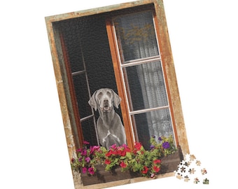 May include: A jigsaw puzzle featuring a Weimaraner dog looking out of a window. The window frame is weathered wood, and a window box below is filled with red, pink, and purple flowers. Some puzzle pieces are separate.