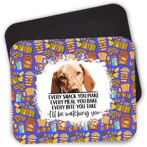 May include: A blue mousepad with a white border and a pattern of various snacks, including popcorn, chips, and chocolate bars. A brown and white dog with a serious expression is in the center of the mousepad. The text "EVERY SNACK YOU MAKE EVERY MEAL YOU BAKE EVERY BITE YOU TAKE -I'll be watching you- " is written below the dog.