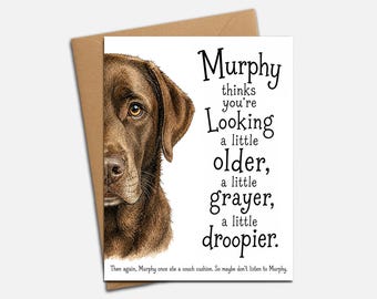 Puede incluir: Una tarjeta de felicitación con una ilustración de un Labrador retriever marrón a la izquierda y texto negro a la derecha: Murphy thinks you're Looking a little older, a little grayer, a little droopier. Then again, Murphy once ate a couch cushion.