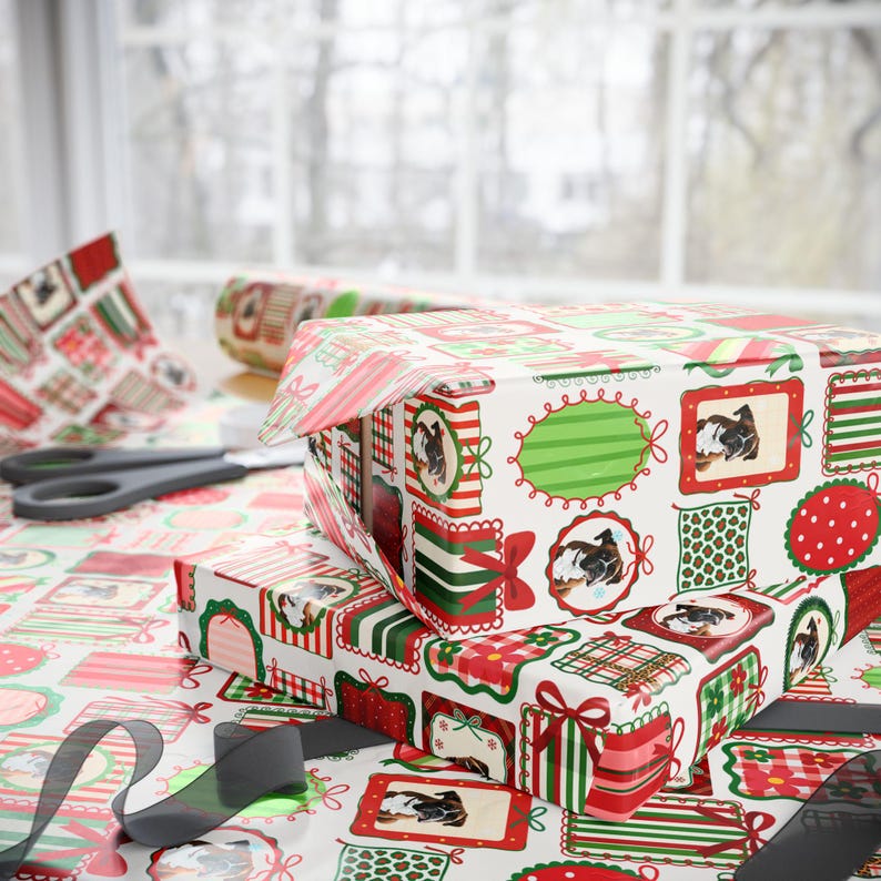 a close-up view of a Christmas-themed gift wrapping paper with various patterns and designs, including images of dogs and other festive elements. The wrapping paper is placed on a table, and there are scissors visible in the scene.