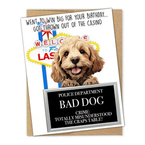 May include: A humorous birthday card featuring a cartoon dog with a police mugshot. The card reads "Went to win big for your birthday... got thrown out of the casino." and "Police Department Bad Dog Crime: Totally misunderstood the craps table!"