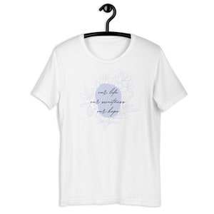 Pode incluir: Camiseta branca com um círculo azul claro e um design floral. O texto dentro do círculo diz "our life our sweetness our hope".