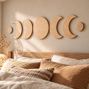 May include: A set of six light-colored wooden wall art pieces depicting the phases of the moon, arranged horizontally. The set includes two small circles, two crescent shapes, one larger crescent, and one large central full moon circle.