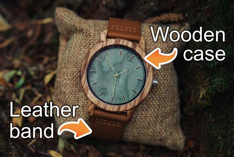 May include: A wooden wristwatch with a brown leather band. The watch face has a green background with gold-colored hands and markings. The text "Wooden case" is written above the watch and "Leather band" is written below the watch.