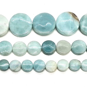 Puede incluir: Tres hileras horizontales de cuentas redondas, planas y con forma de moneda en varios tonos de azul claro, verde azulado y verde mar. Las cuentas presentan un veteado mineral natural, inclusiones blancas y un acabado pulido y suave.