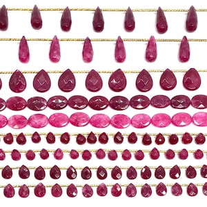 Może przedstawiać: Rzędy fasetowanych, ciemnoczerwonych koralików z kamieni szlachetnych w różnych kształtach, w tym łezki i owale, nawleczonych na złoty drut. Koraliki różnią się rozmiarem i odcieniem, tworząc atrakcyjny wizualnie wygląd. Idealne do tworzenia biżuterii.