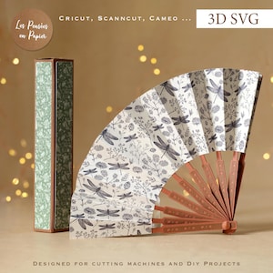May include: A 3D SVG paper folding fan with a white background featuring a black dragonfly and floral pattern, paired with a matching rectangular box. The fan has brown structural ribs and is designed for use with Cricut, Scanncut, and Cameo machines.