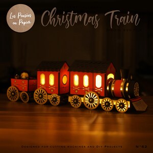 K&ouml;nnte beinhalten: Ein roter und schwarzer Weihnachtszug aus Holz mit Lichtern. Der Zug hat drei Wagen, darunter eine Lokomotive, einen Personenwagen und einen G&uuml;terwagen. Der Zug ist f&uuml;r Schneidemaschinen und DIY-Projekte konzipiert.