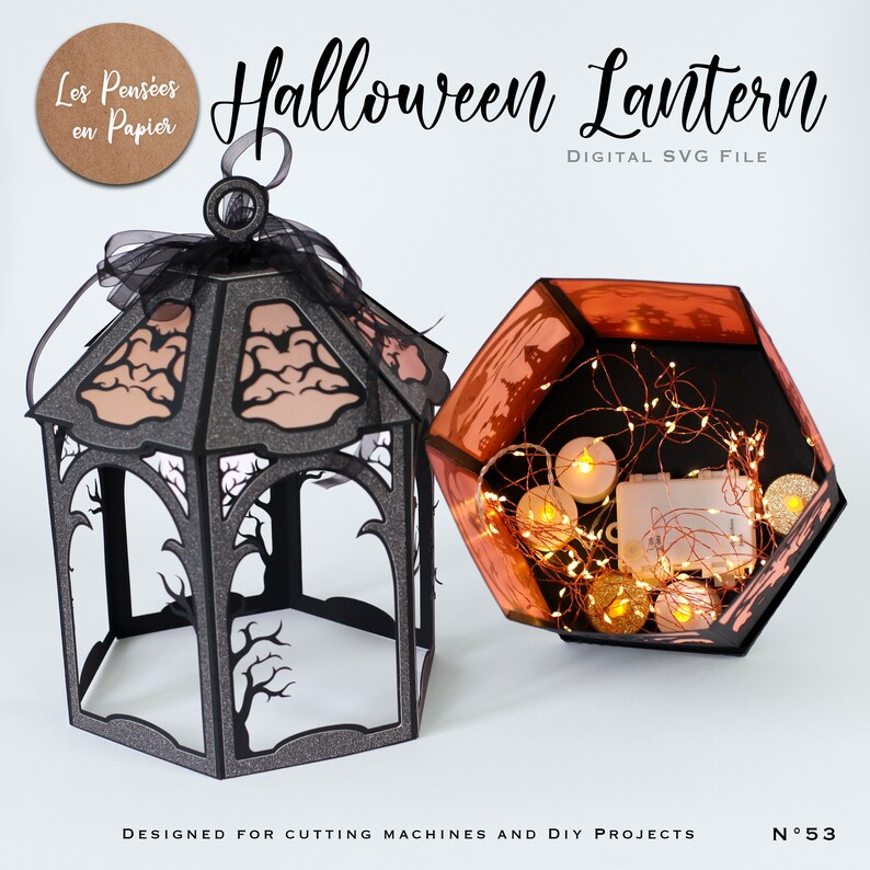 Puede incluir: Un farol de Halloween de papel negro brillante con siluetas de &aacute;rboles recortadas y un lazo negro en la parte superior. Al lado, una base hexagonal contiene una cadena de luces y peque&ntilde;as velas LED. El texto dice Halloween Lantern.