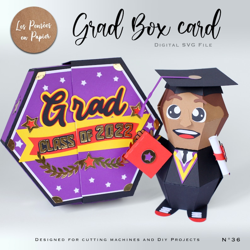 May include: A purple and gold graduation box card with a 3D graduation cap figure holding a diploma. The box card features the text "Grad Class of 2022" and stars.