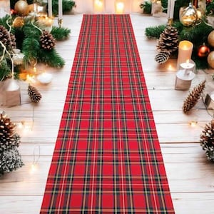 May include: Red and black plaid table runner with a white background. The runner is made of a soft, woven fabric and has a classic plaid pattern.