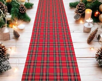 May include: Red and black plaid table runner with a white background. The runner is made of a soft, woven fabric and has a classic plaid pattern.