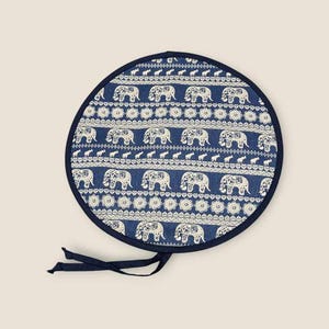 Peut inclure: Coussin de chaise rond en tissu bleu et blanc avec un motif d'éléphants blancs sur fond bleu. Le coussin est doté d'une bordure bleu marine et d'une cravate.