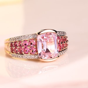 May include: A rose gold ring with a large pink gemstone surrounded by smaller pink gemstones and diamonds.