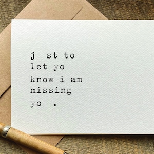 May include: A white card with black text that reads "Just to let you know I am missing you."