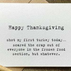 May include: A white greeting card with a textured surface featuring black typewriter-style text that reads: Happy Thanksgiving, shot my first turkey today... scared the crap out of everyone in the frozen food section, but whatever.