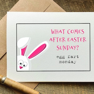 May include: A white bunny with pink ears peeks out from the corner of a card. The card has black text that reads "What comes after Easter Sunday? egg fart monday".