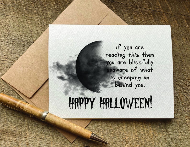 May include: A white card with a black and white illustration of a crescent moon with clouds. The card has the text "if you are reading this then you are blissfully unaware of what is creeping up behind you. HAPPY HALLOWEEN!"