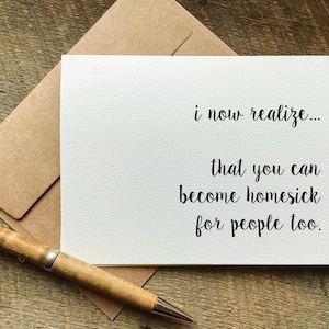 May include: A white card with black text that reads "i now realize... that you can become homesick for people too."