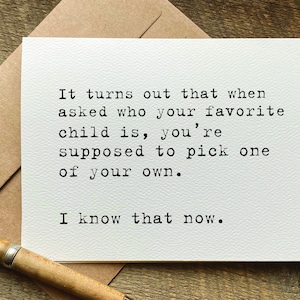 Puede incluir: Una tarjeta de felicitación rectangular blanca con texto negro estilo máquina de escribir: It turns out that when asked who your favorite child is, you're supposed to pick one of your own. I know that now. La tarjeta está sobre un sobre marrón.