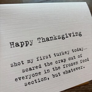 May include: A white greeting card with a textured surface featuring black typewriter-style text that reads: Happy Thanksgiving, shot my first turkey today... scared the crap out of everyone in the frozen food section, but whatever.