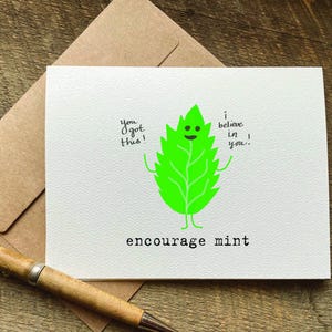 May include: A white card with a green cartoon mint leaf with a smiling face. The text on the card reads "You got this! I believe in you." and "Encourage Mint".